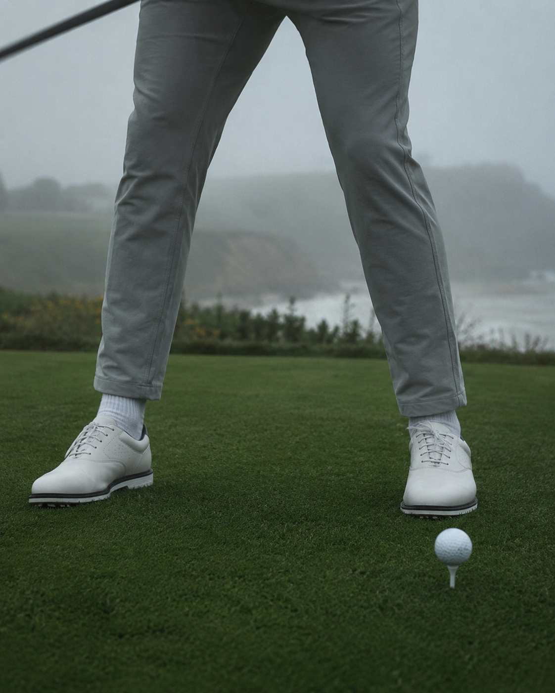 Golfer addressing the ball, grounded stance on the tee